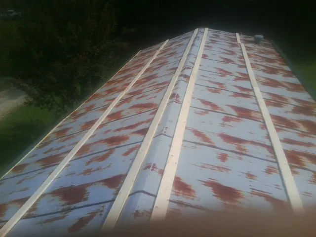 Rusted metal roof panels with new wood purlins before replacement — Storm Damage Roof Repair in Rochester by Roofing Brothers